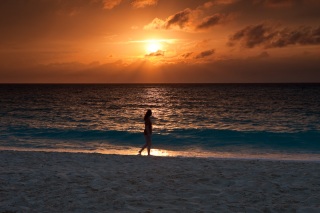Rhonda walking on the beach at sunset.