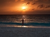 Rhonda walking on the beach at sunset.