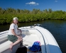 Rhonda leaning over the edge looking for jellyfish and urchins in a mangrove.